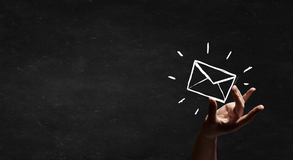 Person hand taking chalk drawn email sign-1 Person hand taking chalk drawn email sign-1
